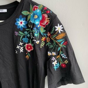 Black tee with floral embroidered design on shoulder